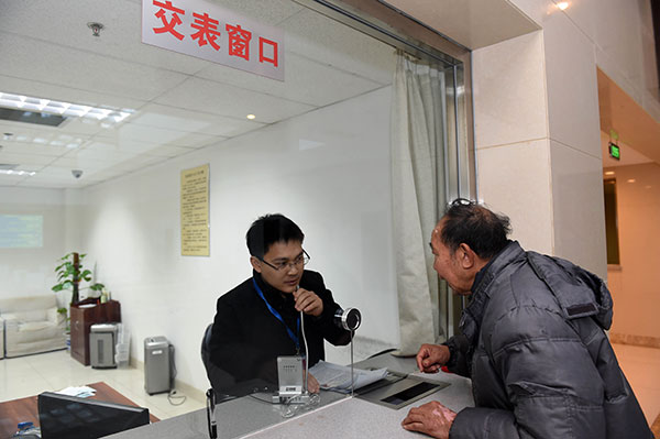 工作人员接收群众递交的表格，并解答群众咨询问题。