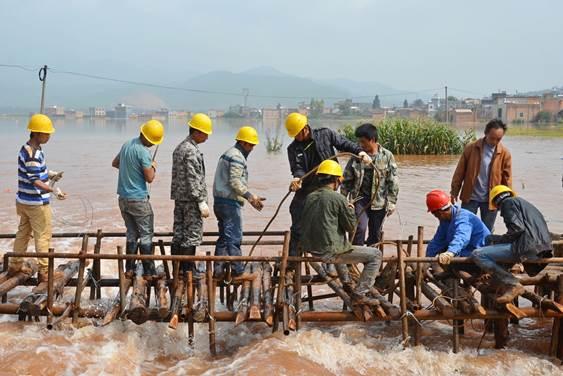 强暴雨导致云南省陆良县板桥镇大坝冲水库决堤，当地纪检监察干部与党员群众一起搭建拦截坝，将人民群众生命财产损失降到最低。（云南陆良纪委  王勇  15887976780）